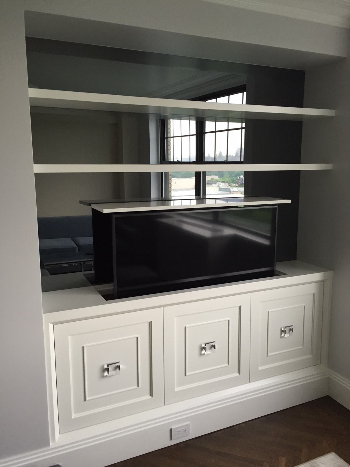 Modern built-in shelving with pop-up TV